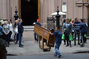 Workers removing pews from a church to refinish them