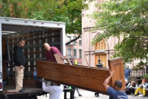 Workers loading church pews into a truck to restore